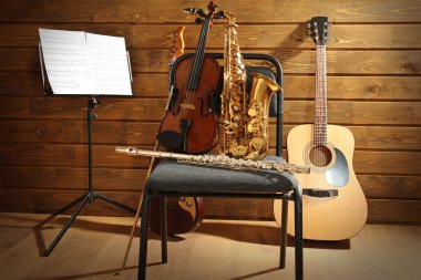 Müzik aletleri üzerinde ahşap arka plan karşı bir sandalye ve Not tutucu