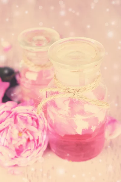 Rose olajat, a palackban a háttérben — Stock Fotó