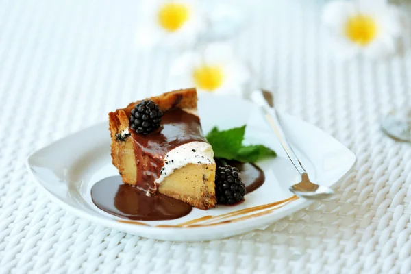 Leckerer Kuchen unter Schokoladenglasur mit Brombeere und Minze — Stockfoto