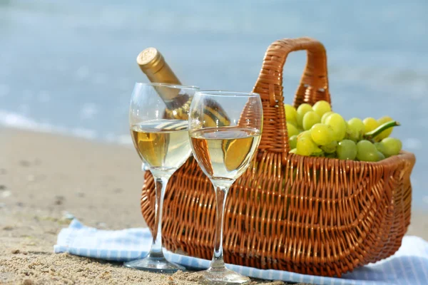 Cesta de piquenique com garrafa de vinho na praia de areia — Fotografia de Stock