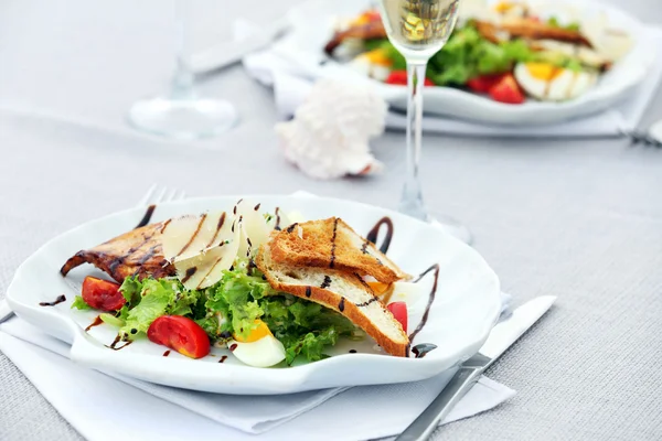 Tasty salad with wine on white served table — Stock Photo, Image
