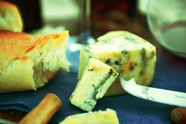 Beautiful romantic composition of red wine, bread and nuts on sandy beach, close up