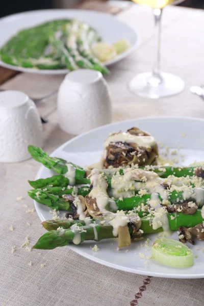 Piatto appetitoso con asparagi e funghi sul tavolo servito nel ristorante — Foto Stock