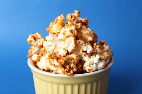 Sweet caramel popcorn on blue background — Stock Photo, Image