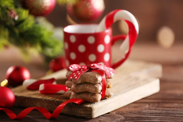 Canas de caramelo de Navidad en taza con decoración de Navidad en la mesa sobre fondo brillante —  Fotos de Stock