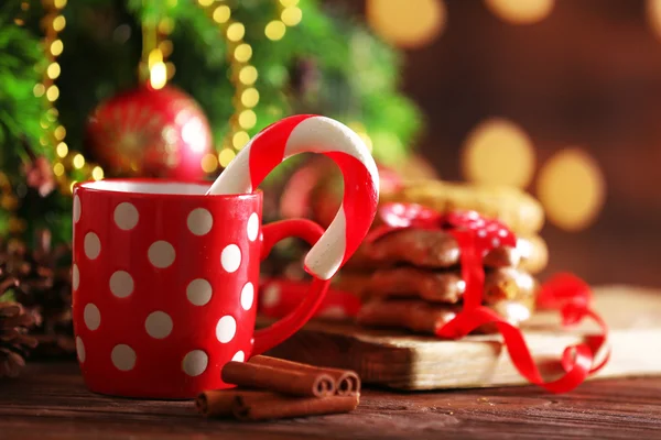 Bastoncini di zucchero natalizio in tazza con decorazione natalizia sul tavolo su sfondo luminoso — Foto Stock