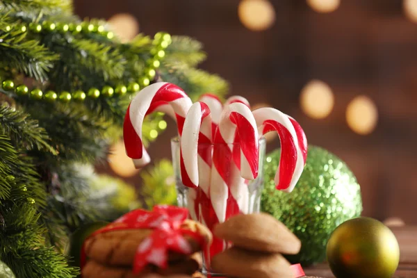Canas de caramelo de Navidad en vidrio con decoración de Navidad en la mesa sobre fondo brillante —  Fotos de Stock
