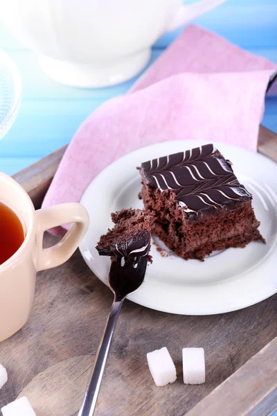 Сервированный стол с чашкой чая и шоколадным тортом на деревянном фоне крупным планом — стоковое фото