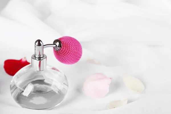 Garrafa de perfume e pétalas de rosa — Fotografia de Stock