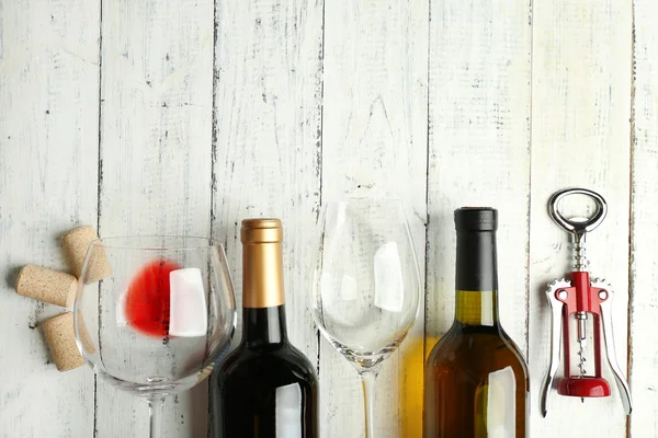 Garrafa de vinho e rolhas na mesa de madeira — Fotografia de Stock