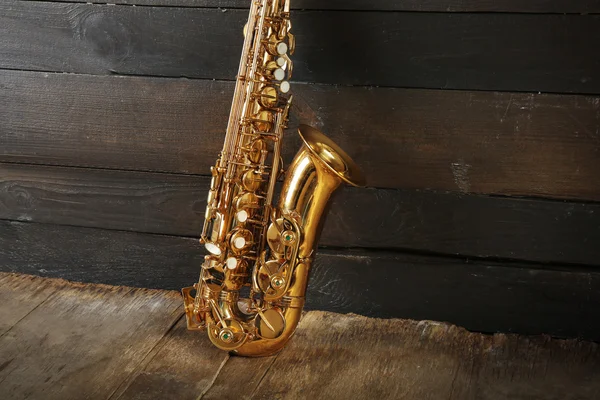 Hermoso saxofón dorado sobre fondo de madera, de cerca — Foto de Stock
