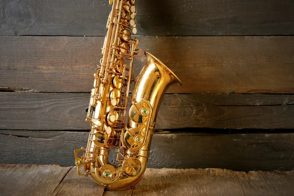 Beautiful golden saxophone on wooden background, close up — Stock Photo, Image