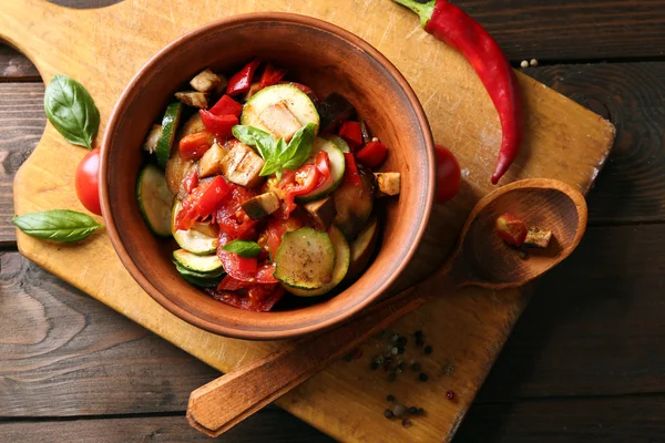 Вкусный вегетарианский рататуй из баклажанов, сквоша, помидоров в миске на деревянном столе — стоковое фото