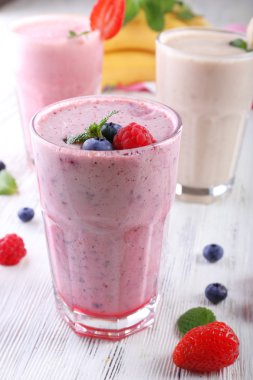 Milkshakes hafif ahşap arka plan üzerinde çilek ile yakın çekim