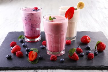 Kesme tahtası üzerinde açık renkli meyveleri ile at milkshakes