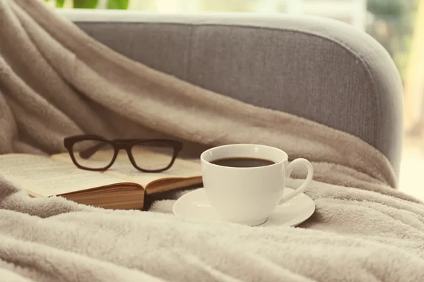 Kopje koffie met boek op sofa in kamer — Stockfoto