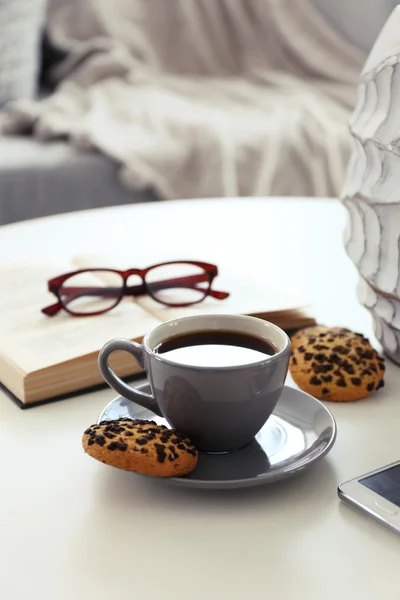 Xícara de café com biscoitos na mesa no quarto — Fotografia de Stock