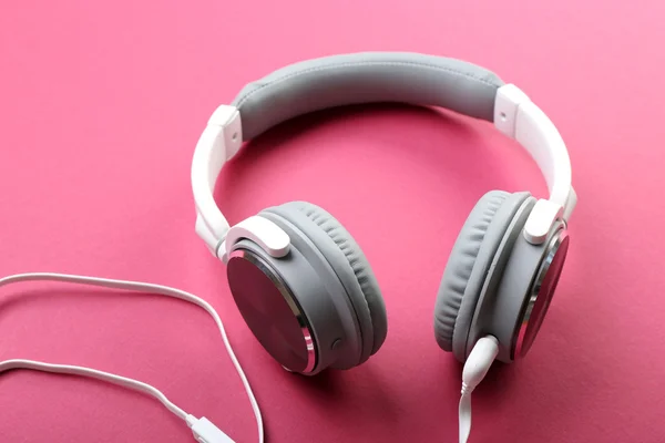 Bílé a šedé sluchátka na růžovém pozadí — Stock fotografie