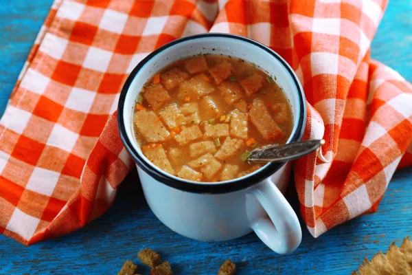 Tazza di zuppa e tovagliolo su sfondo blu in legno — Foto Stock