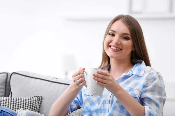 Молодая женщина пьет чай дома — стоковое фото