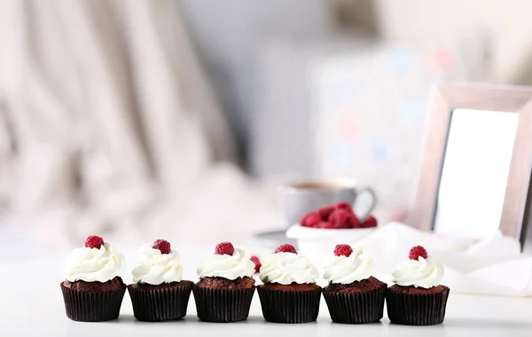 Vackra choklad muffins med grädde och hallon på bord — Stockfoto