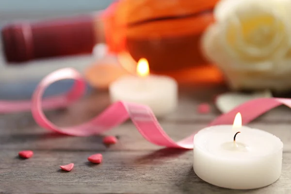 Una botella de vino, una vela y una rosa blanca, sobre fondo de madera — Foto de Stock