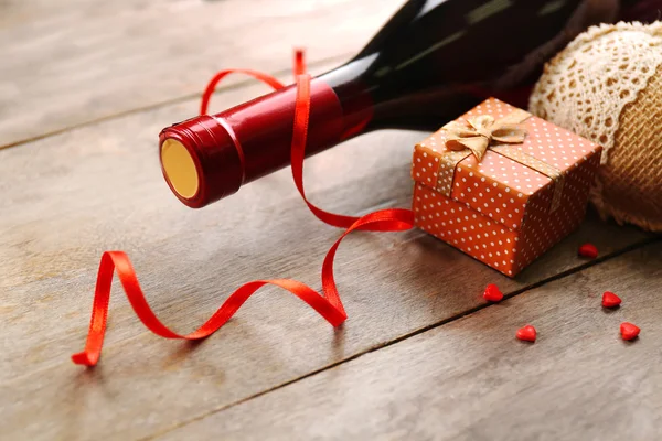 Ustawienie butelki wina, prezent w polu i innych dekoracji, na tle drewniane — Zdjęcie stockowe