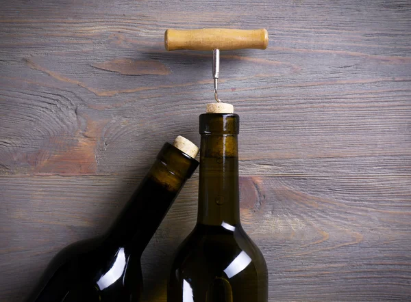 Dos botellas de vino y sacacorchos sobre fondo de madera púrpura —  Fotos de Stock