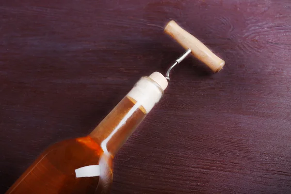 Tirbuşon ve mor ahşap arka plan üzerinde şarap şişesi — Stok fotoğraf