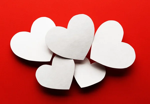 Papel branco corações no fundo vermelho — Fotografia de Stock