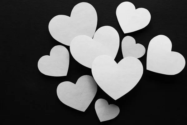Siyah arka plan üzerine beyaz kağıt Kalpler — Stok fotoğraf