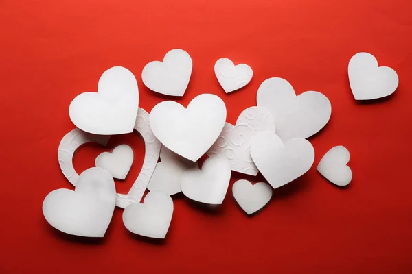 Kırmızı arkaplanda beyaz kağıt kalpler — Stok fotoğraf