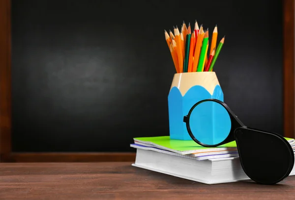 Ceruza, könyv, jegyzetfüzet és iskolapad háttér nagyító — Stock Fotó