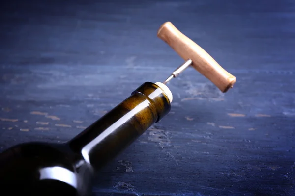 Korkociąg i butelkę wina na niebieskim tle drewniane — Zdjęcie stockowe
