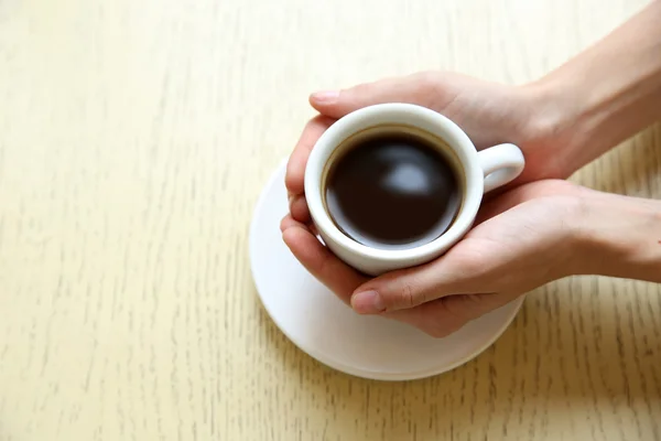 Secangkir kopi dengan tangan di atas meja latar belakang — Stok Foto