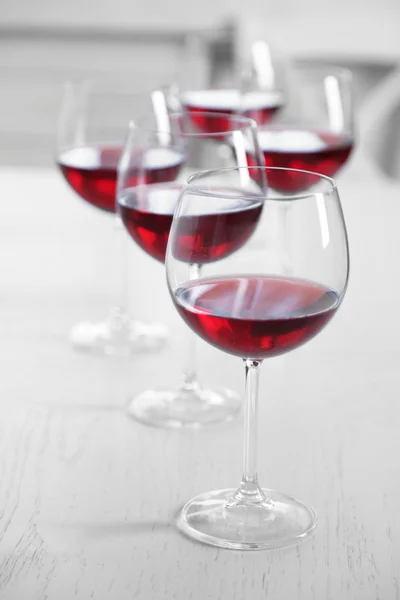 Copos de vinho tinto na mesa sobre fundo brilhante — Fotografia de Stock