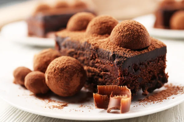 Slices of chocolate cake with a truffle on plate closeup