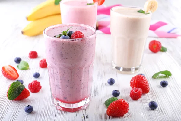 Milkshakes with berries on light wooden background — Stock Photo, Image