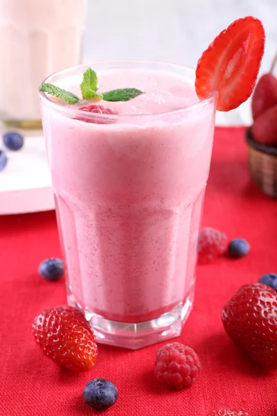 Mléčné koktejly s plody na červená textilní na světlé pozadí — Stock fotografie