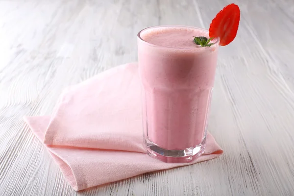 Milkshake com guardanapo no fundo de madeira — Fotografia de Stock