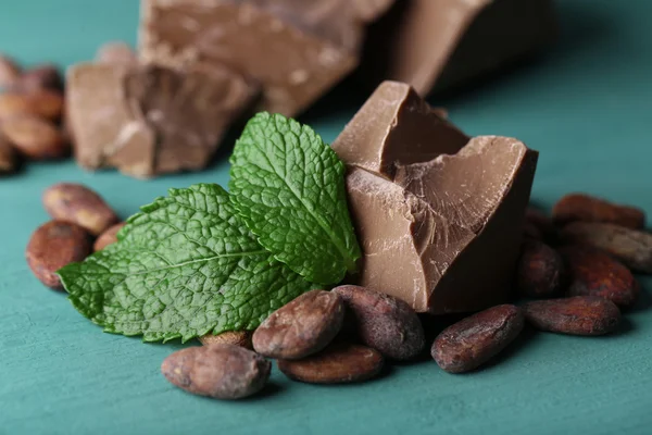 ミルク チョコレート部分と木製の背景の色のココア豆 — ストック写真