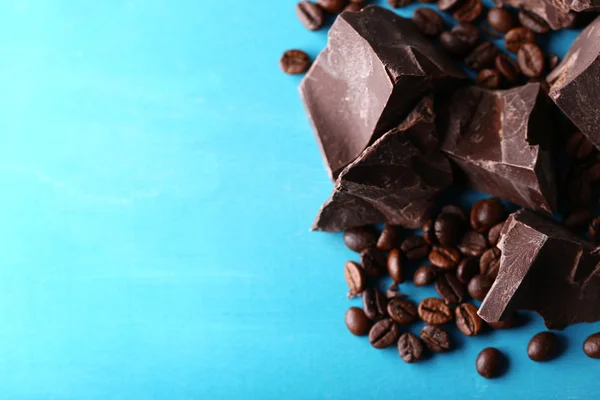 Siyah çikolata parçaları ve renk ahşap arka plan üzerinde kahve taneleri — Stok fotoğraf