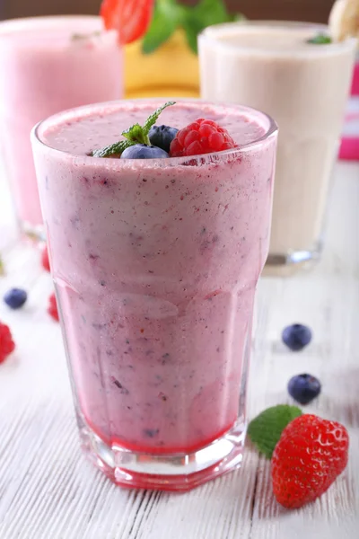 Milchshakes mit Beeren auf hellem Holzgrund, Nahaufnahme — Stockfoto