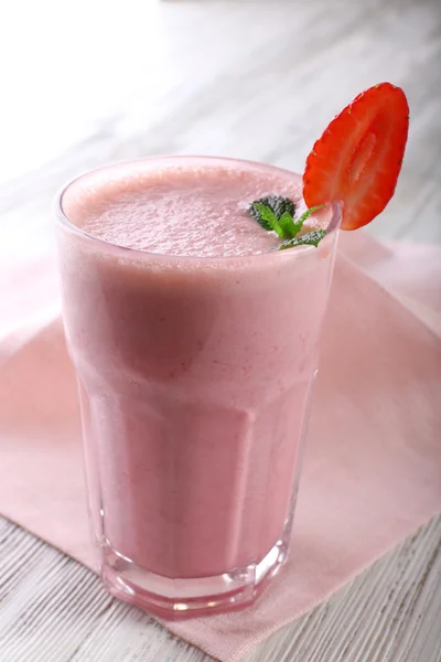 Milkshake with napkin on wooden background, close-up — Stock Photo, Image