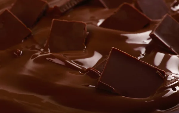 Tło stopiony czekolada mleczna i kawałki z barem, szczelnie-do góry — Zdjęcie stockowe