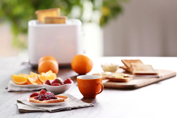 Served table for breakfast with toast, coffee and fruit, on blurred background — Stock Photo, Image