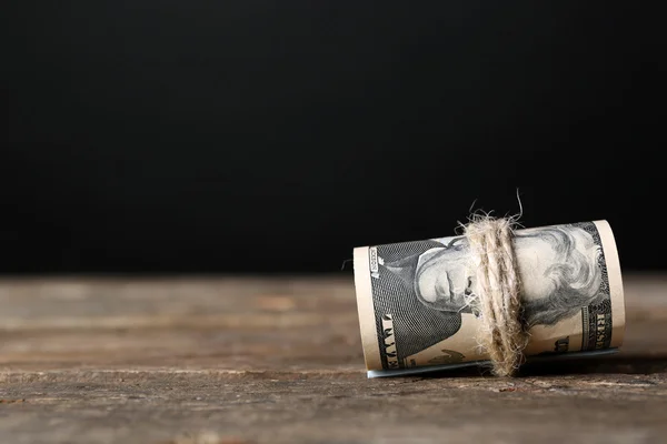 Dollars roll on wooden table — Stock Photo, Image