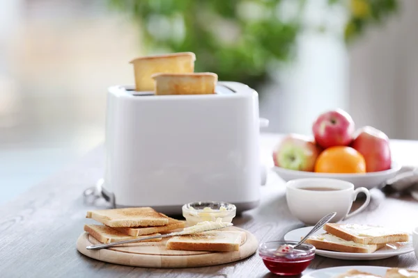 Tavola servita a colazione con pane tostato, caffè e frutta, su sfondo sfocato — Foto Stock