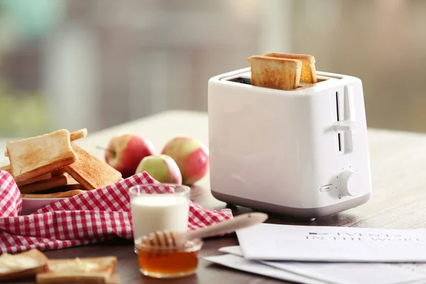 Served table for breakfast with toast, milk and honey, on blurred background — Stock Photo, Image