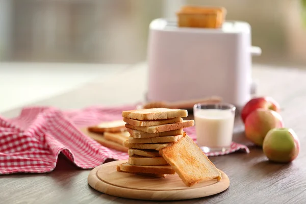 朝食にトースト、牛乳、蜂蜜、背景をぼかした写真とテーブルを用意してください。 — ストック写真